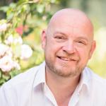RMG's Jason Mather sat smiling in a sunny outdoor space